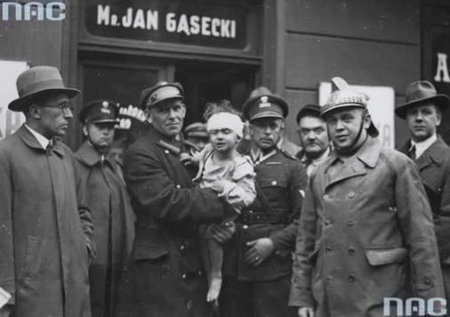 Dziecko wydobyte spod gruzów na rękach ratownika, Freta 16, 1935. Fot. Narodowe Archiwum Cyfrowe.